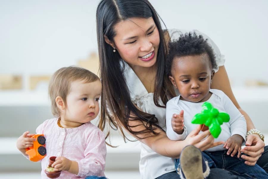 Happy mother and baby with professional nurse at home